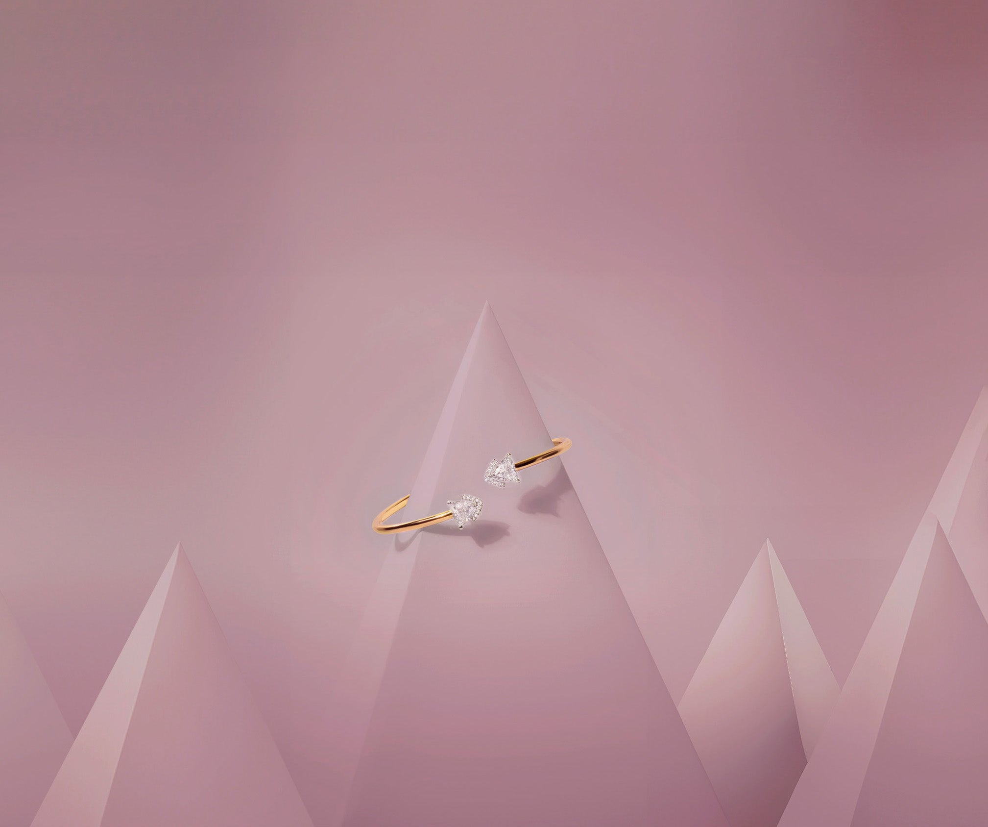 The Victoria Duo bracelet, featuring two 1.45-carat lab-grown diamonds, displayed on a rose-colored pyramid-shaped stand.