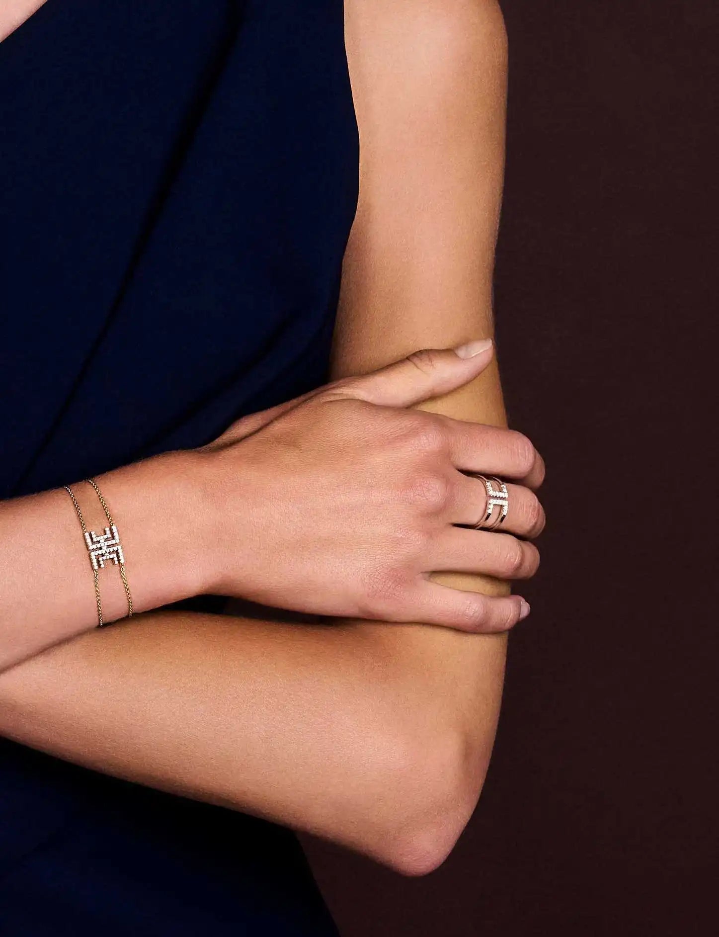 Close up of a model's arm wearing the harper bracelet and Loulou Icon ring.
