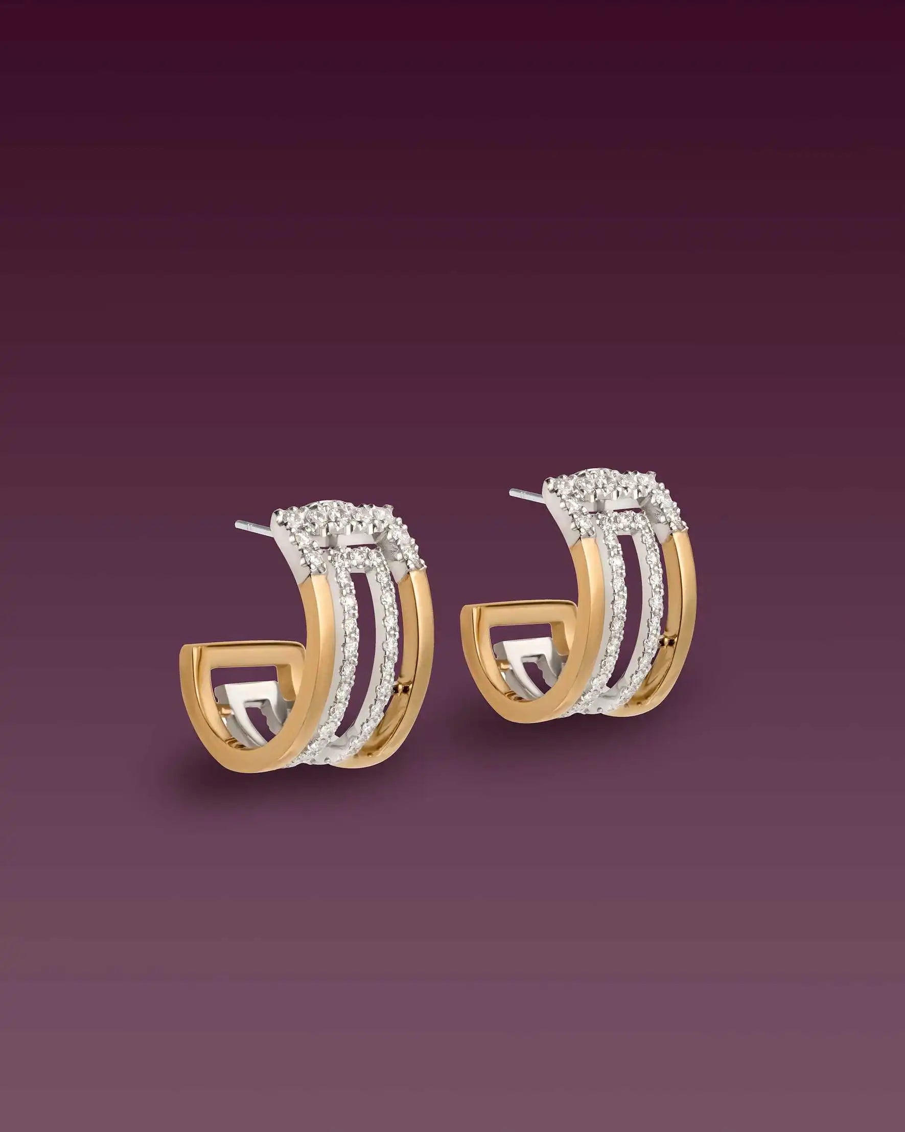 Sideway perspective of the Heloise arcs earrings in bi-colour yellow gold with diamond-studded geometric design, behind a gradient backdrop.