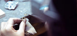 A jeweller carefully assembling the Floating Pear Icon ring in the atelier, using precision tools to craft the gold setting.